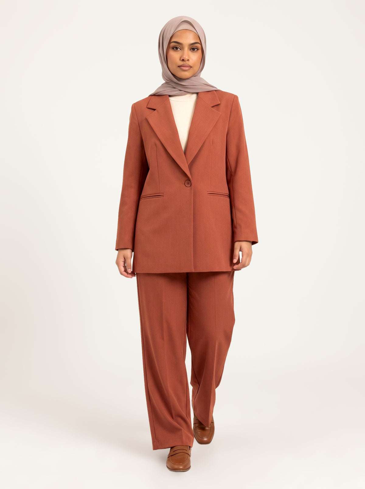 Ensemble tailleur blazer long et pantalon large rouille, porté