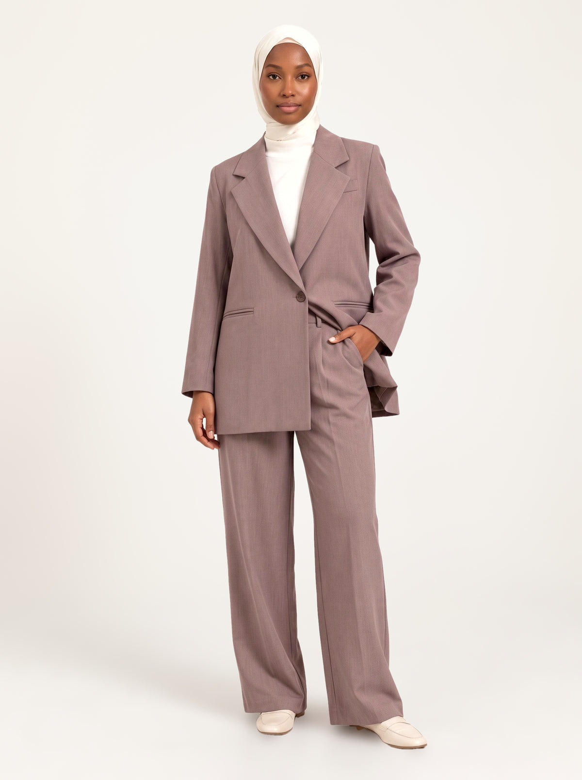 Ensemble tailleur blazer long et pantalon large taupe rosé, porté