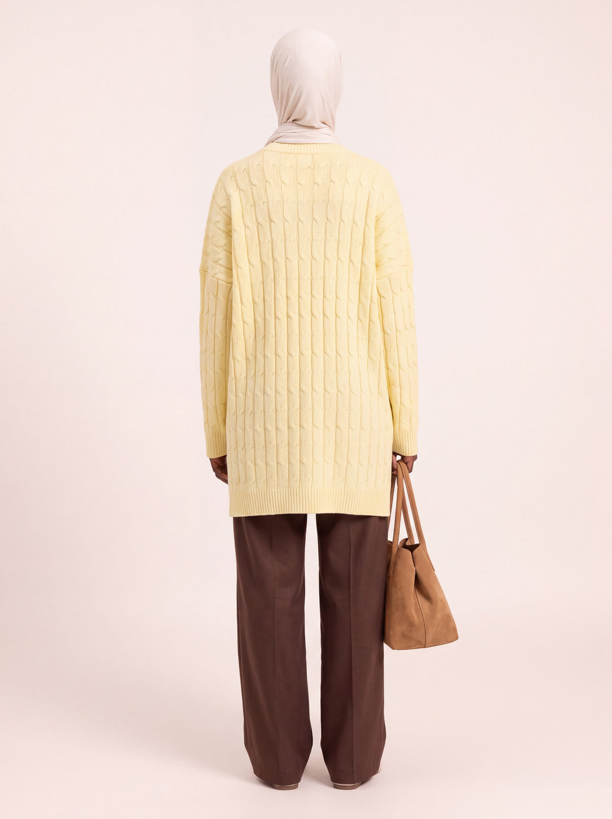 Pull long torsadé oversize jaune pâle porté de dos