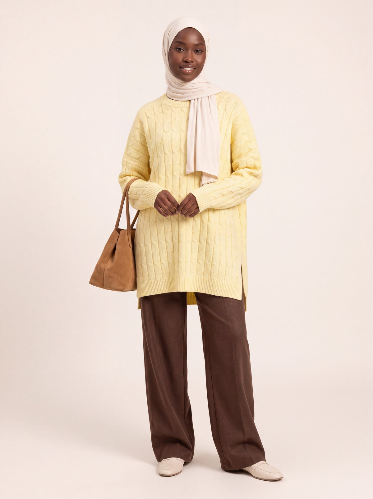Pull long torsadé oversize jaune pâle porté de face