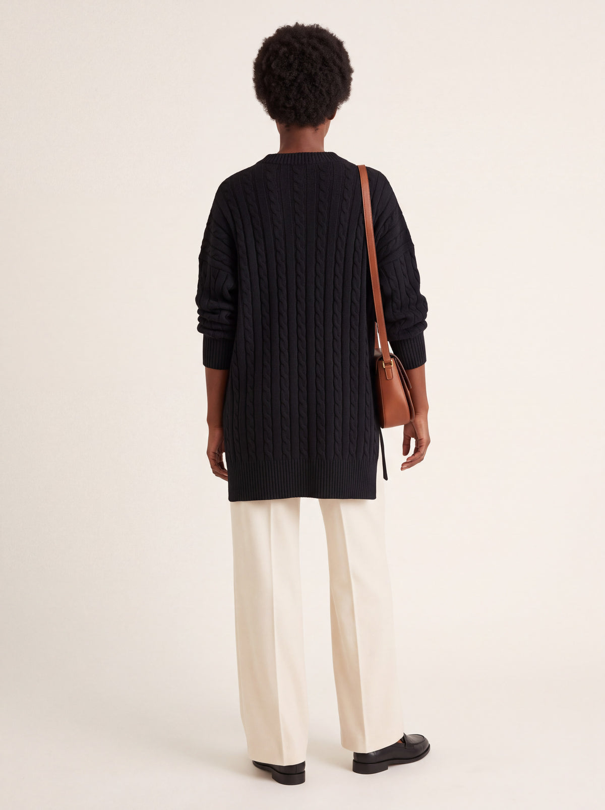 Pull long torsadé oversize noir porté de dos