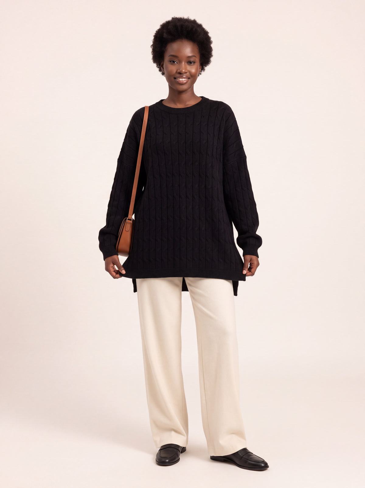 Pull long torsadé oversize noir porté de face
